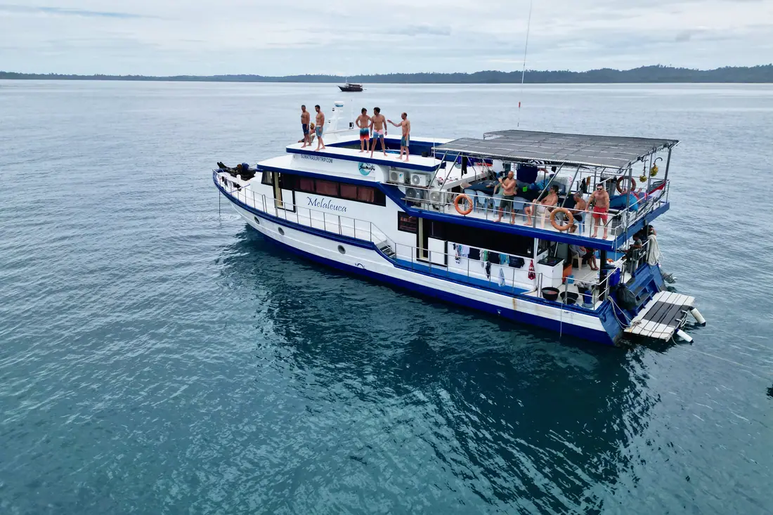 Kaimana at anchor with guests on the upper deck