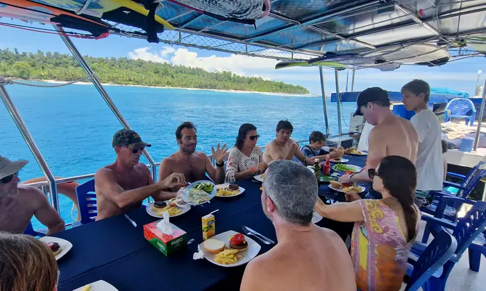 Guests eating lunch together at the outdoor table on deck