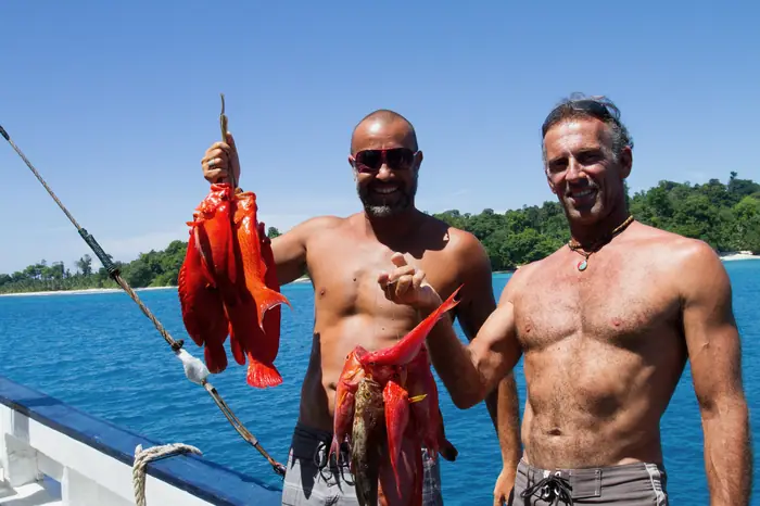 Two crew holding the day's catch on the back deck
